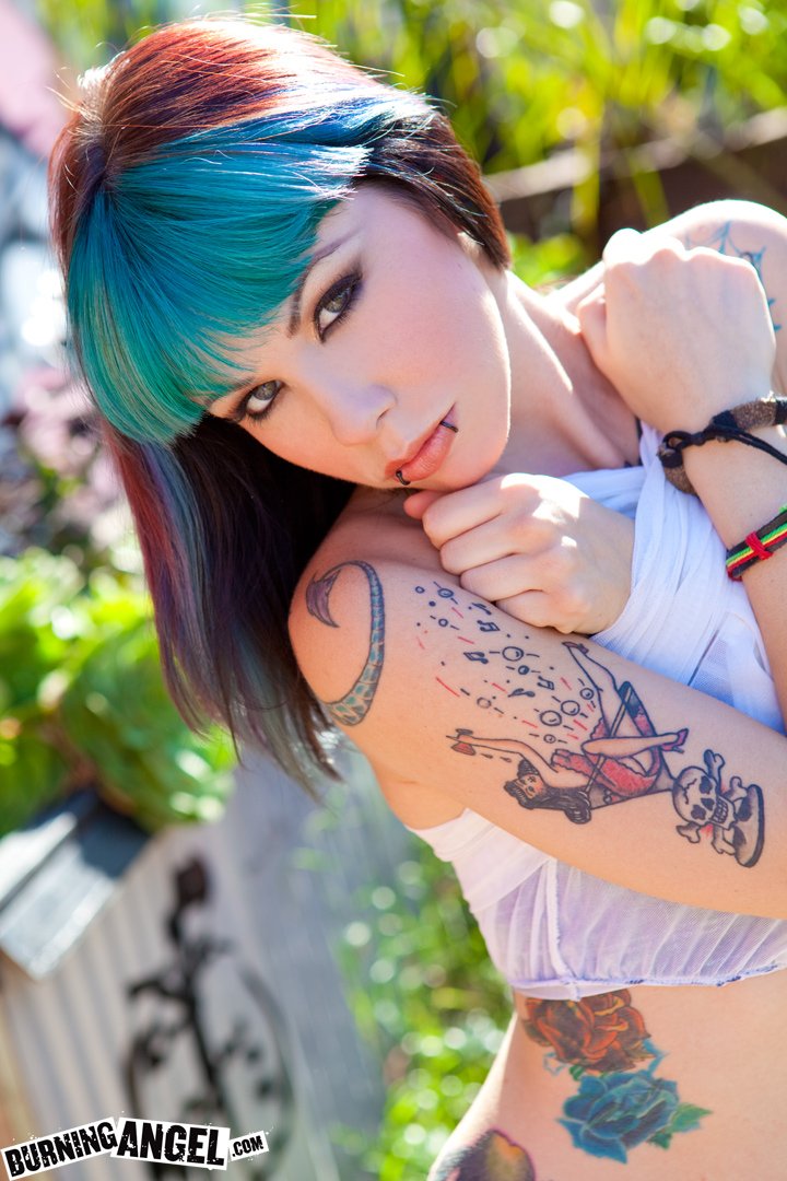 Женщина с татуировками, облаченная в откровенный наряд.