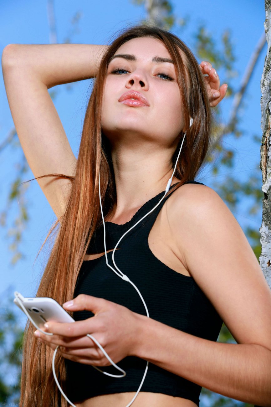 Деревенская девушка в бикини с плеером в лесу